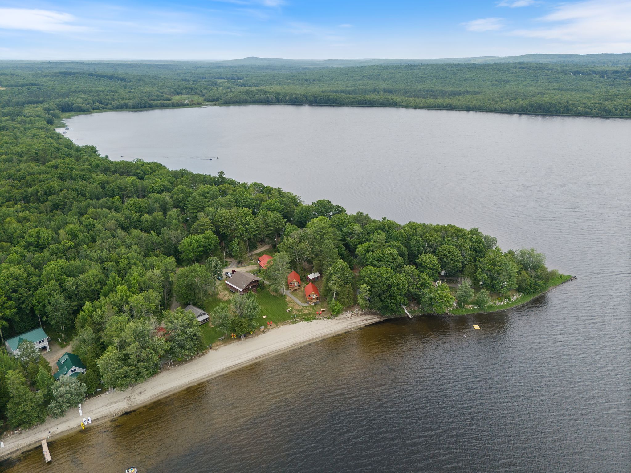 Aerial view showing the cabins and long sandy beach on Lake Winnecook